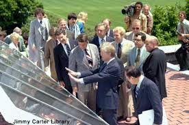 Jimmy Carter explains solar panels to reporters.