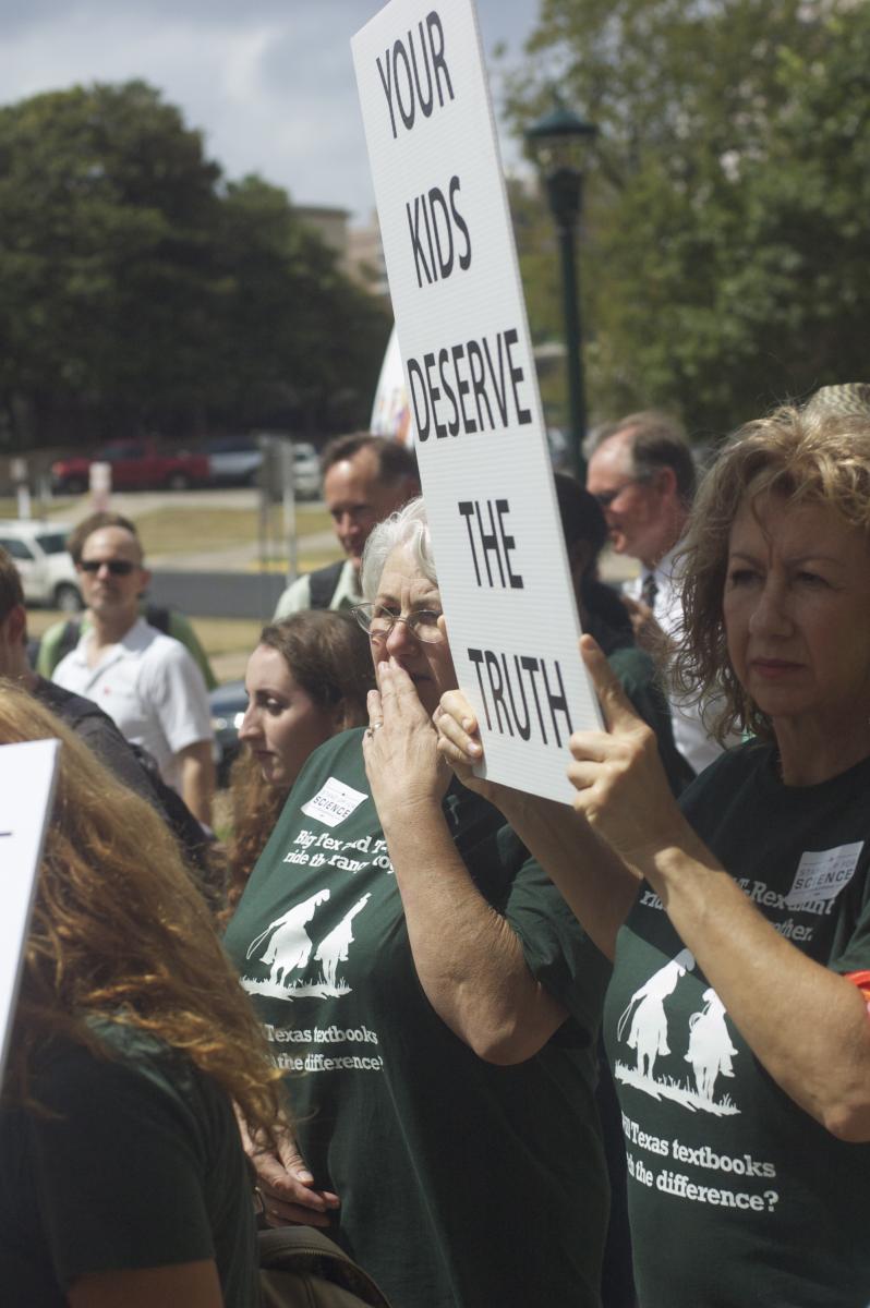 Protesters holding a sign: "Your Kids Deserve The Truth"
