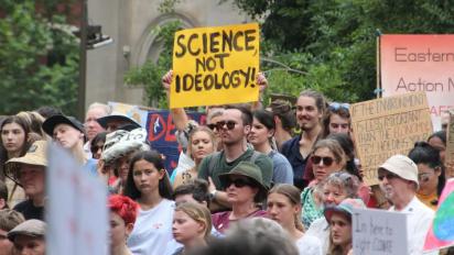"Science not Ideology" poster held up at a climate march.